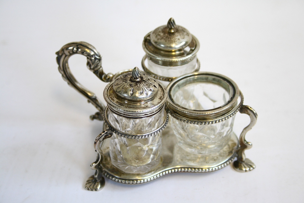 A Victorian small trefoil-shaped cruet frame with beaded rims, foliate scroll handle, & on three