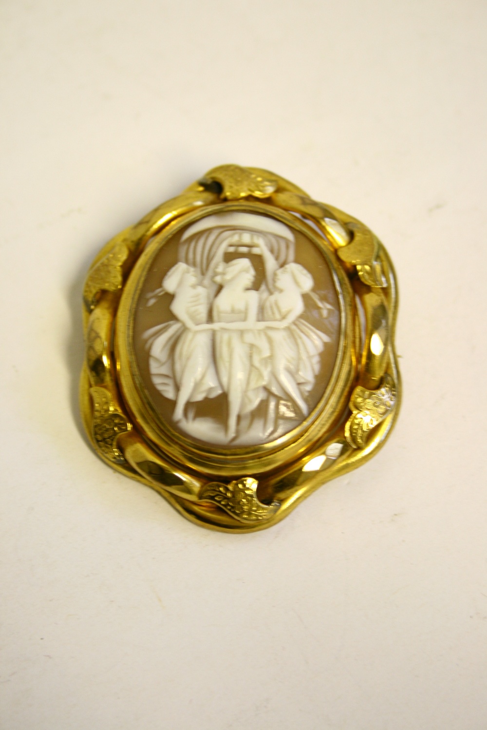 A Victorian yellow metal oval brooch, the revolving centre set carved shell cameo depicting the