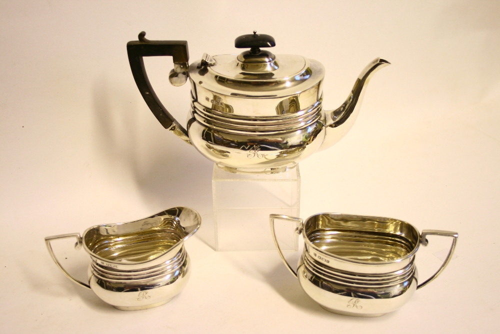 An Edwardian small three-piece tea service of compressed oblong form, each with horizontal reeded