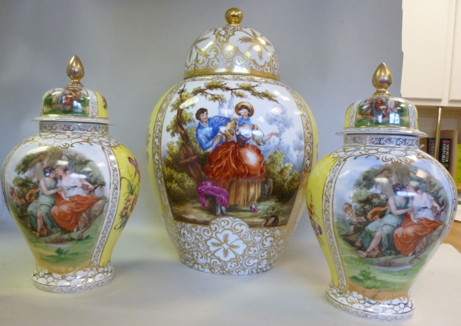 A garniture of three 20thC Czechoslovakian porcelain vases and covers, each decorated with vignettes