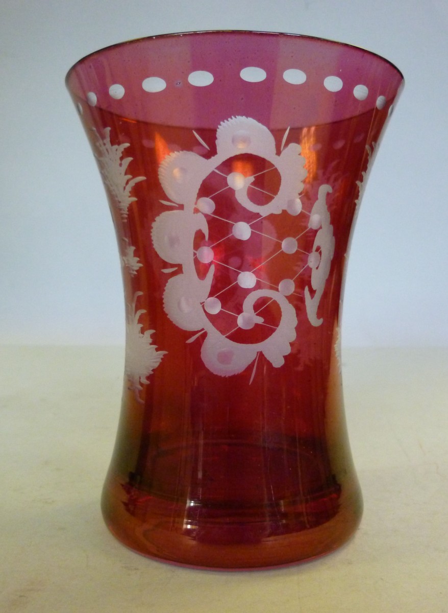 An early 20thC Continental Cranberry glass vase of waisted beaker design, wheel engraved with