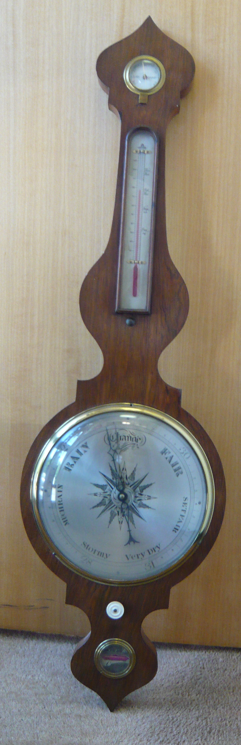 A mid 19thC wheel barometer, the mahogany, banjo shaped case having an onion finial, over a