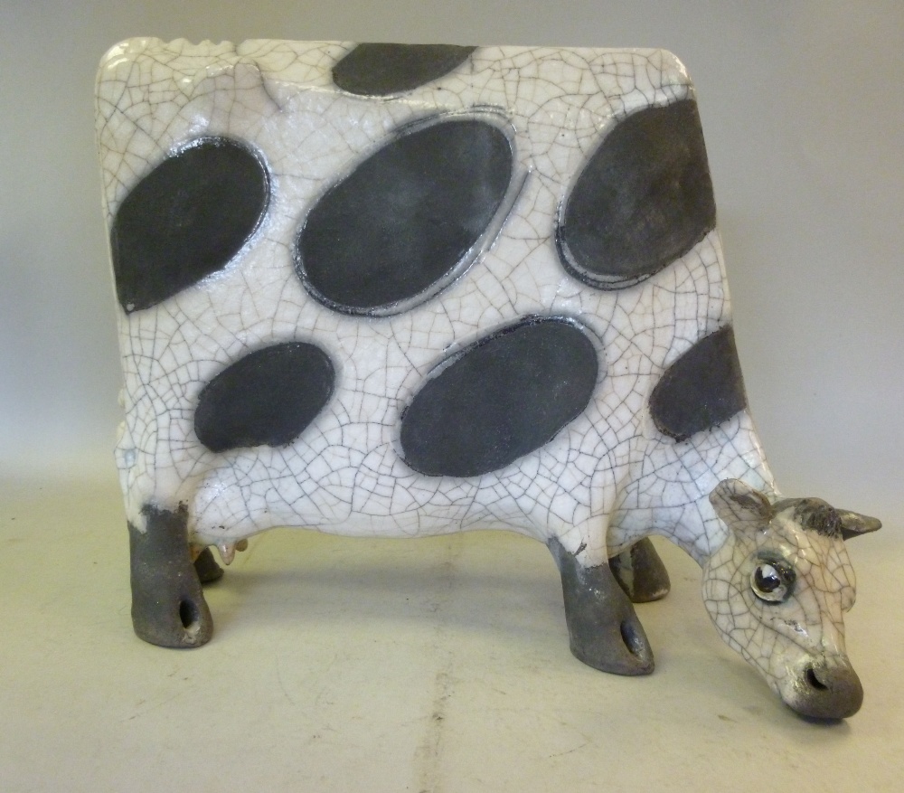 A Lawson E Rudge, raku pottery model `Flat Cow` decorated in black and white, number 252 on one