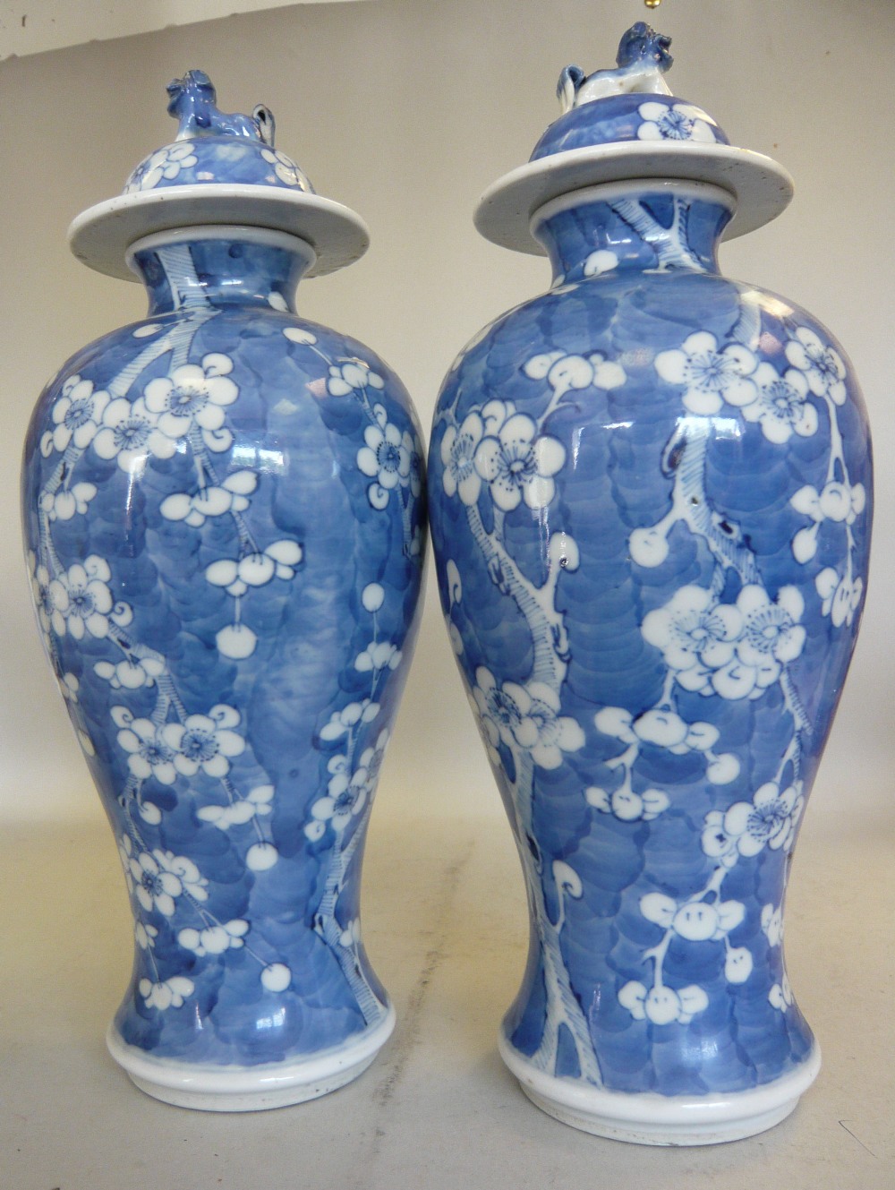 A pair of late 19thC Chinese porcelain temple jars of waisted baluster form with domed covers,