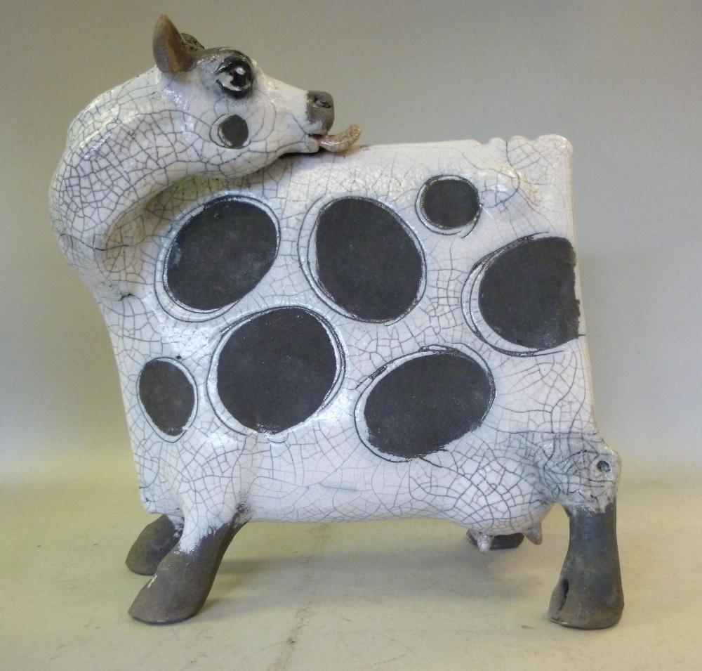 A Lawson E Rudge, raku pottery model `Flat Cow Licking` decorated in black and white, number 55 on a