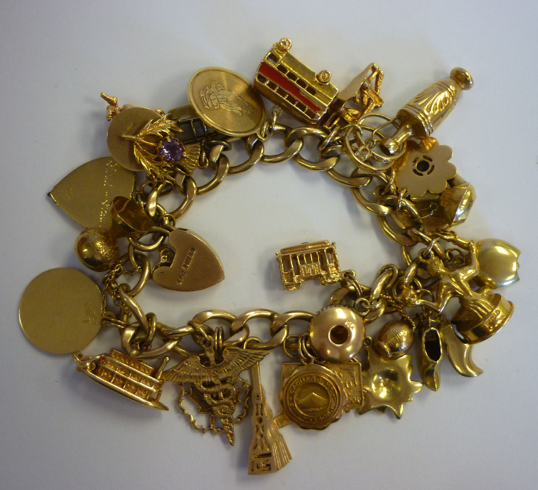 A 9ct gold bracelet with twenty-eight assorted charms