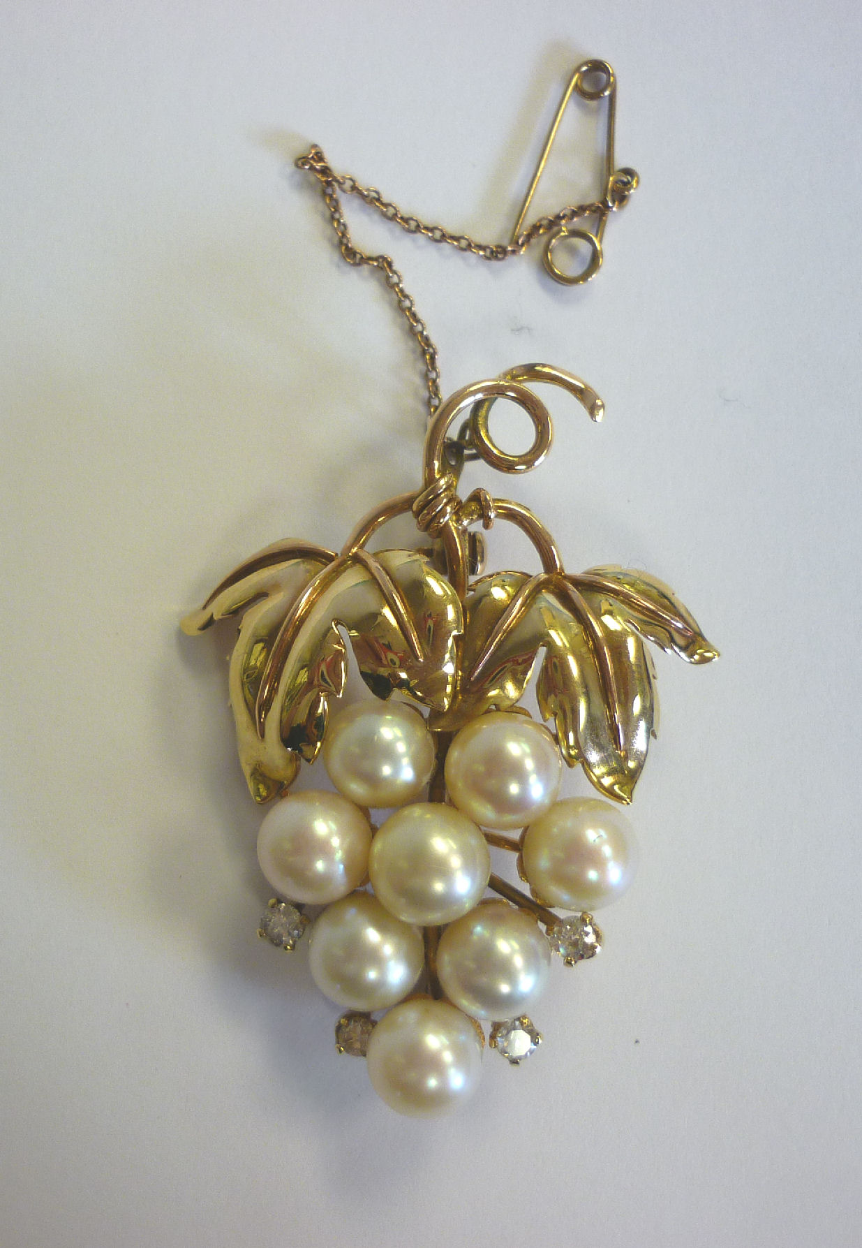A 9ct gold, cultured pearl and diamond set brooch, fashioned as a bunch of grapes, on a safety chain