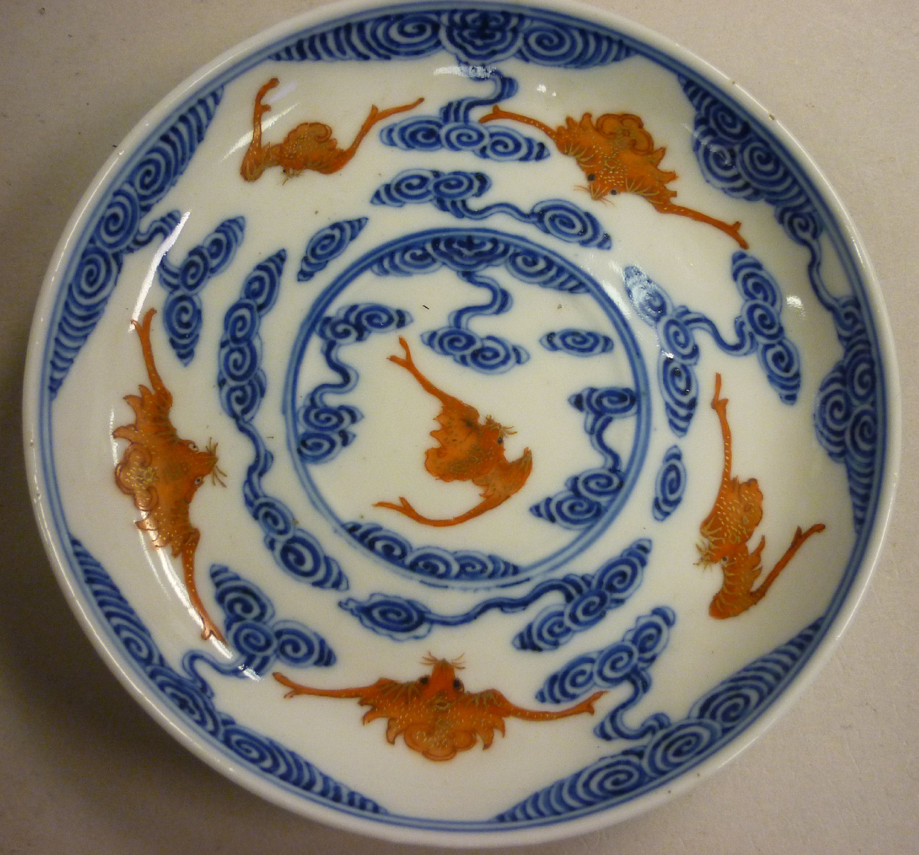 A late 19th/early 20thC Chinese porcelain saucer dish, decorated in blue, iron red and gilding