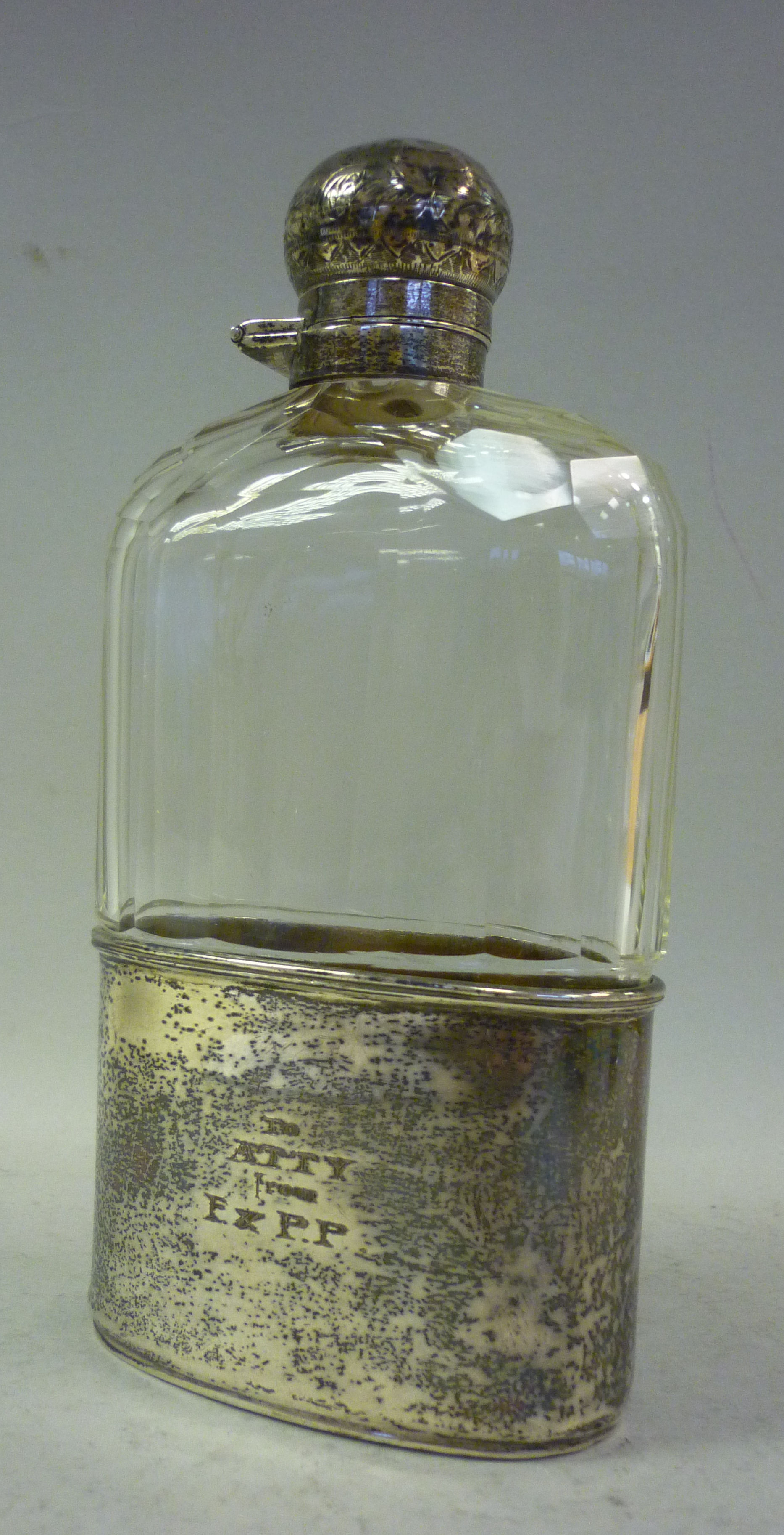 A late Victorian shouldered, facet cut glass hip flask with an applied silver collar, an outset