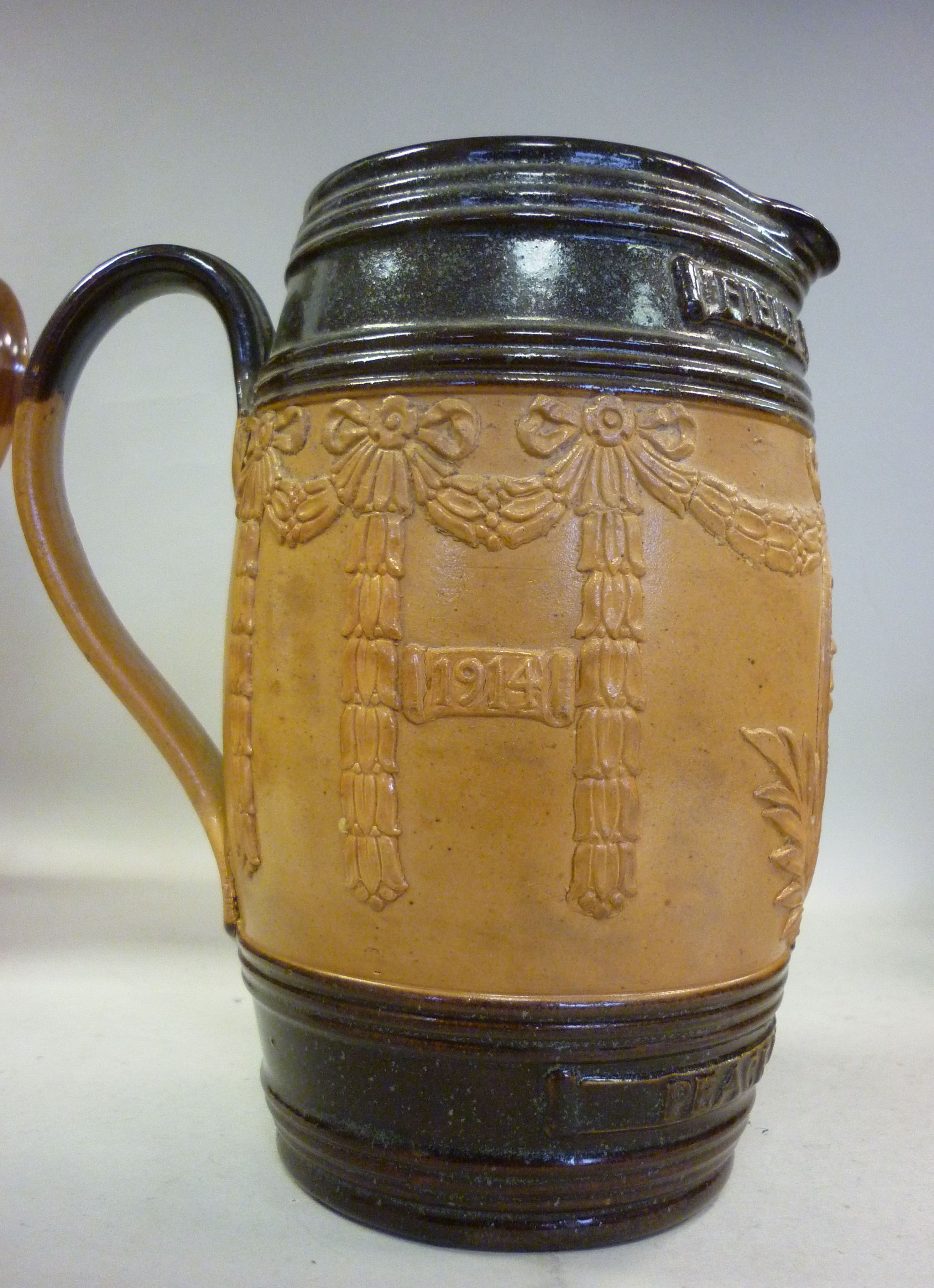 A Royal Doulton two tone brown glazed stoneware jug of barrel design with a pouring lip and loop