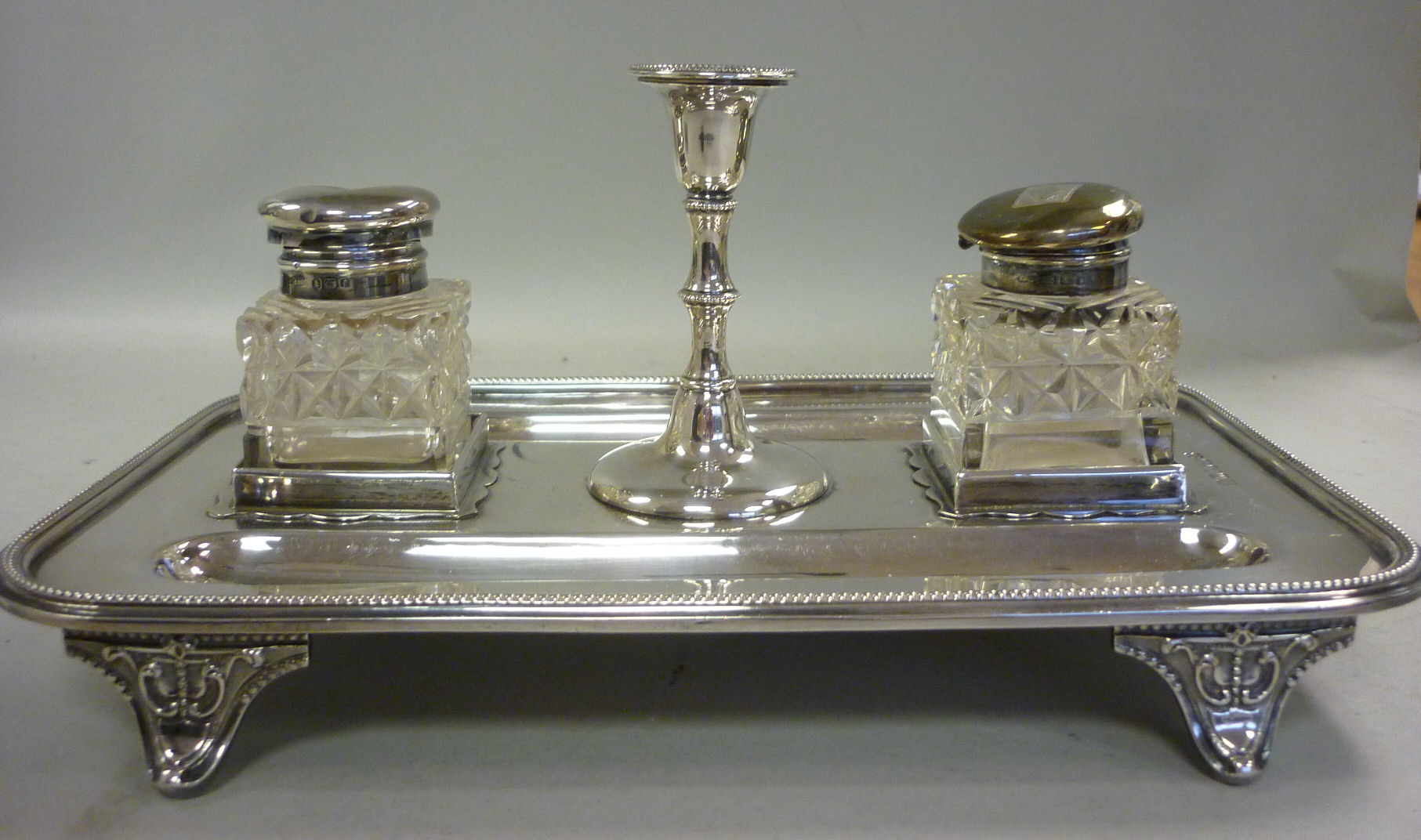 A late Victorian silver standish, the rectangular, bead bordered tray incorporating twin pen