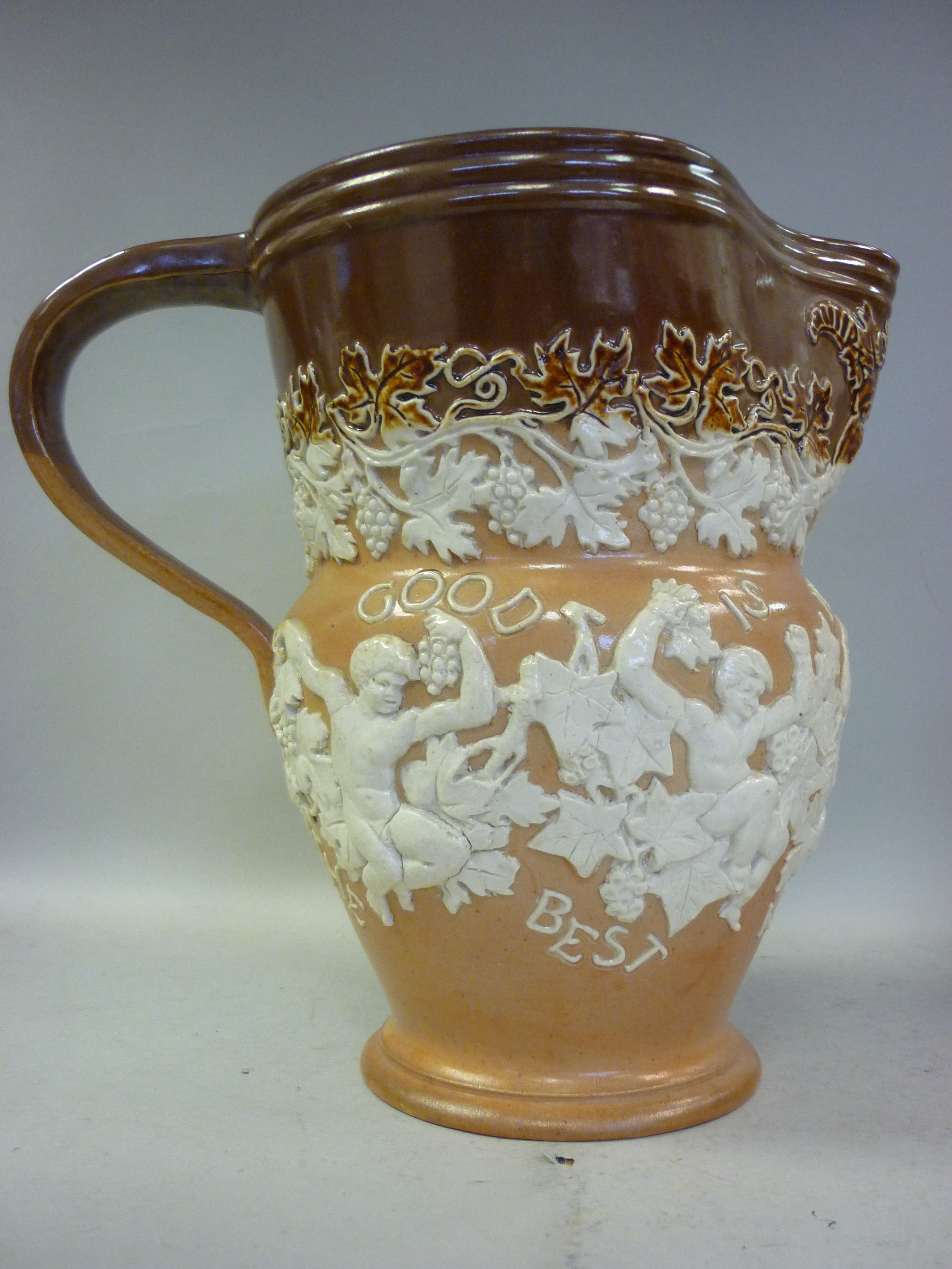 A Doulton Lambeth two tone brown glazed stoneware jug of waisted form, having a wide, flared rim,