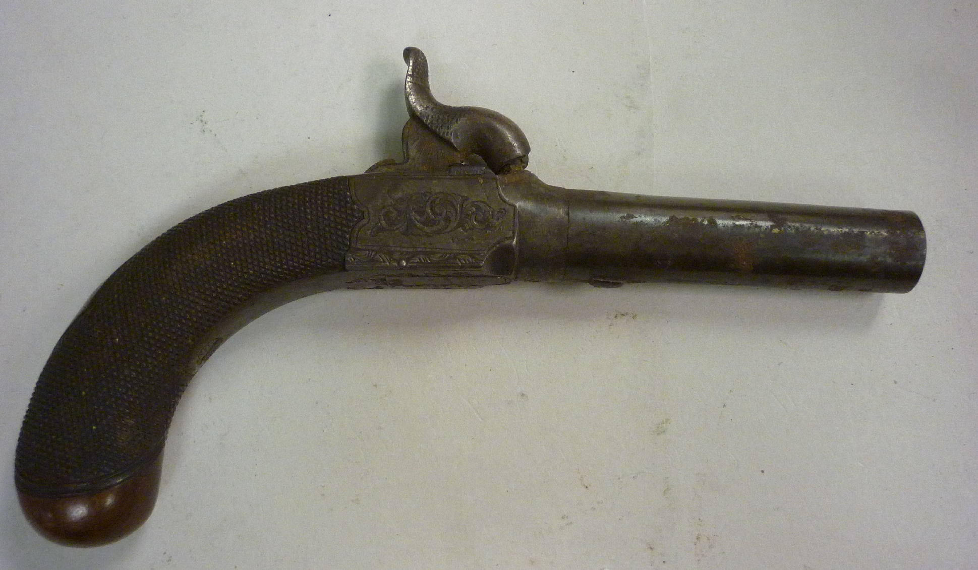 An early 19thC percussion action muff pistol with a fish-tail design hammer and scroll engraved