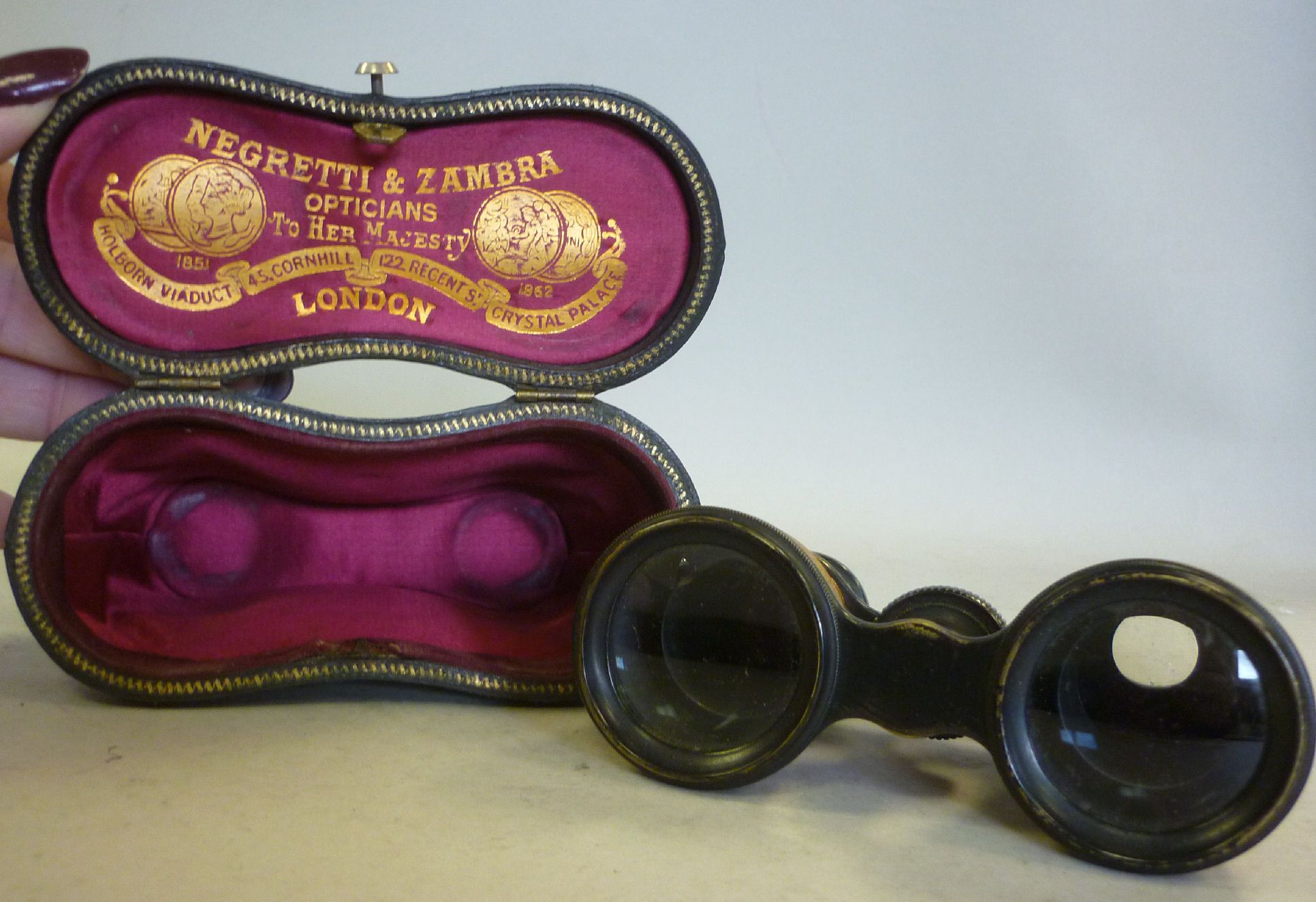 A pair of late Victorian Negretti & Zambra black enamelled brass opera glasses with textured