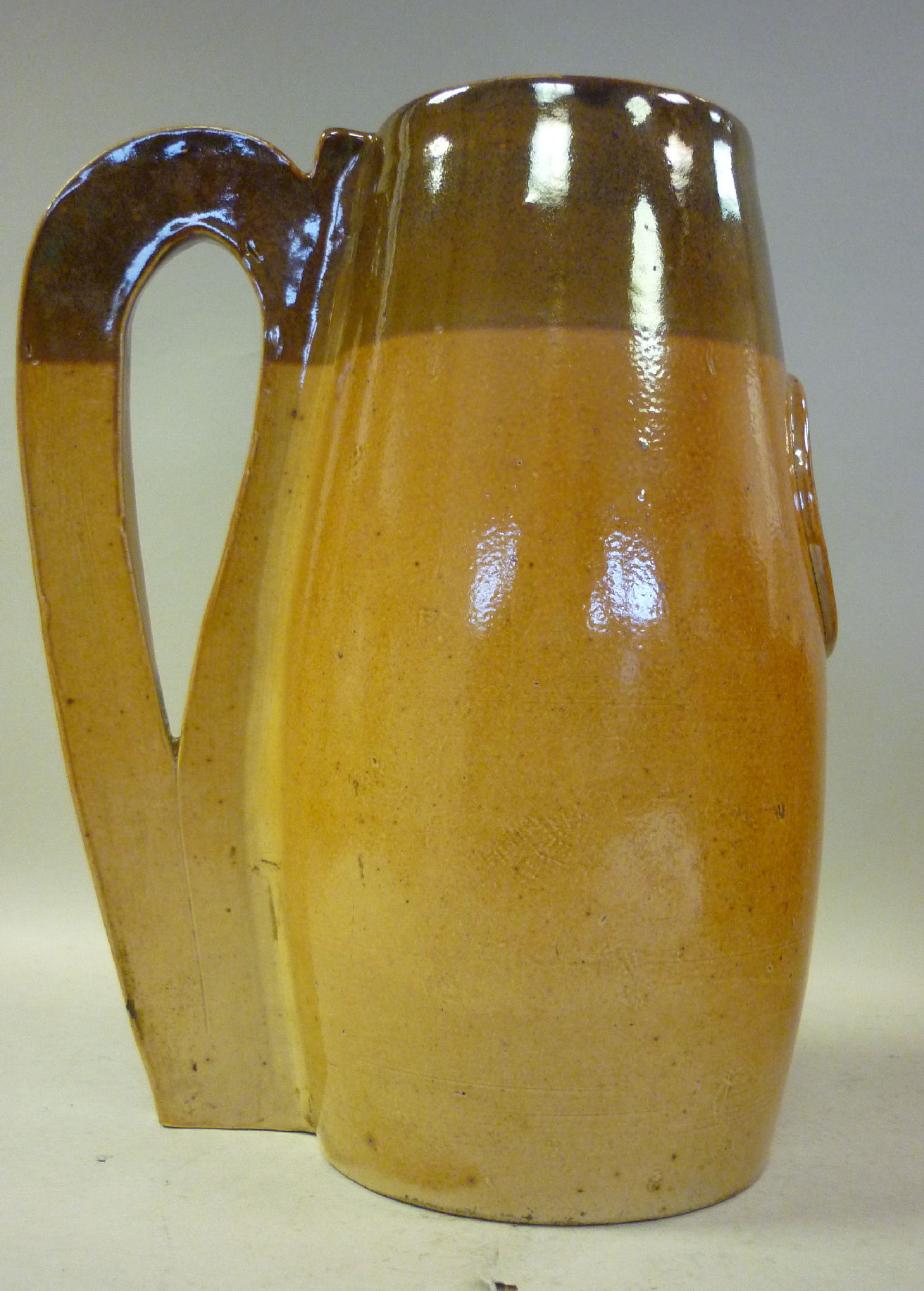 A late 19thC Doulton Lambeth two tone brown glazed stoneware jug of slender, baluster form, having a