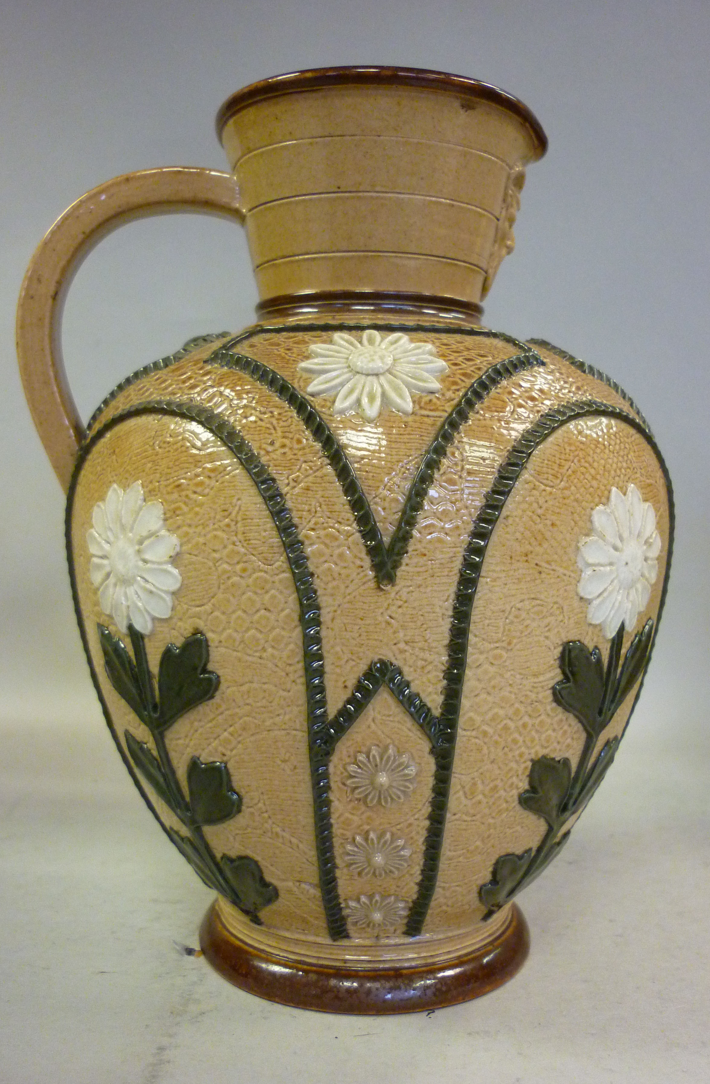 A late 19thC Doulton Lambeth two tone brown glazed stoneware ewer of ovoid form, having a narrow