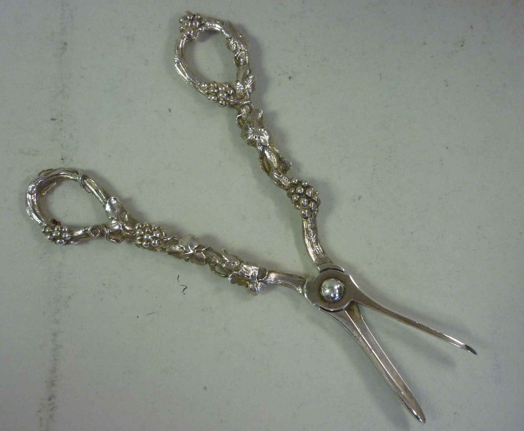 A pair of silver grape scissors, the arms cast with fruiting vines BLF London 1988