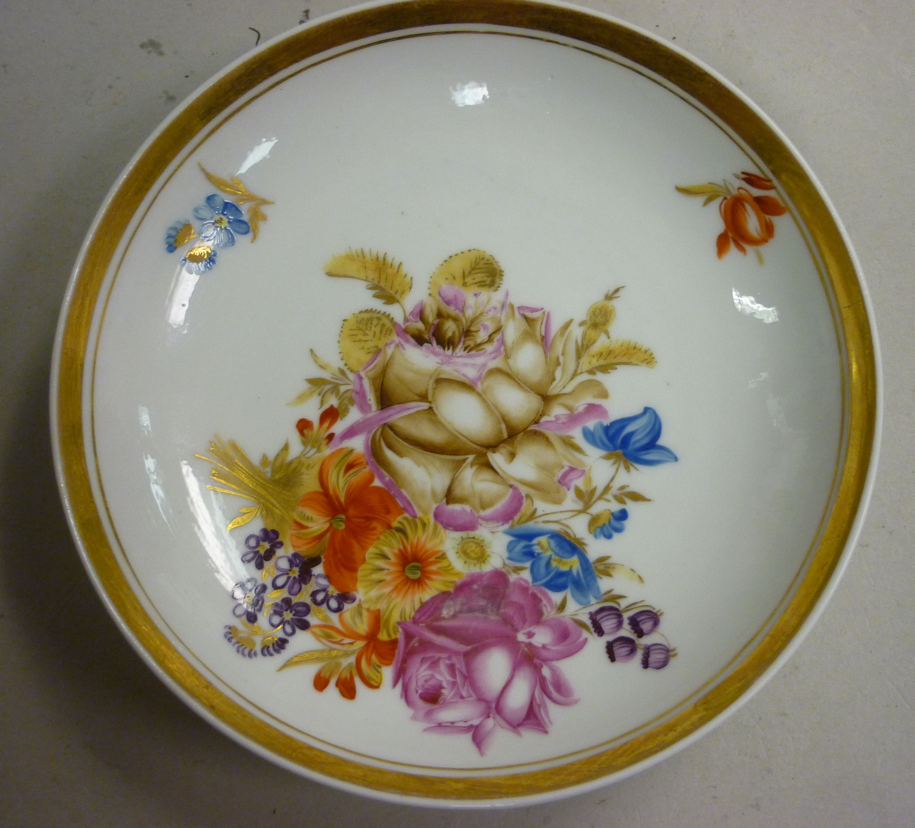 An early 19thC Russian (Moscow) porcelain saucer dish, decorated with flowers and highlighted in