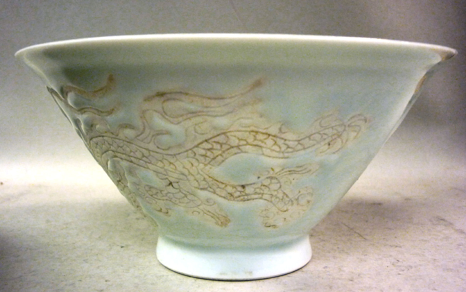 An early 20thC Chinese porcelain footed bowl, having an inverted rim and scrafitto carved and inlaid