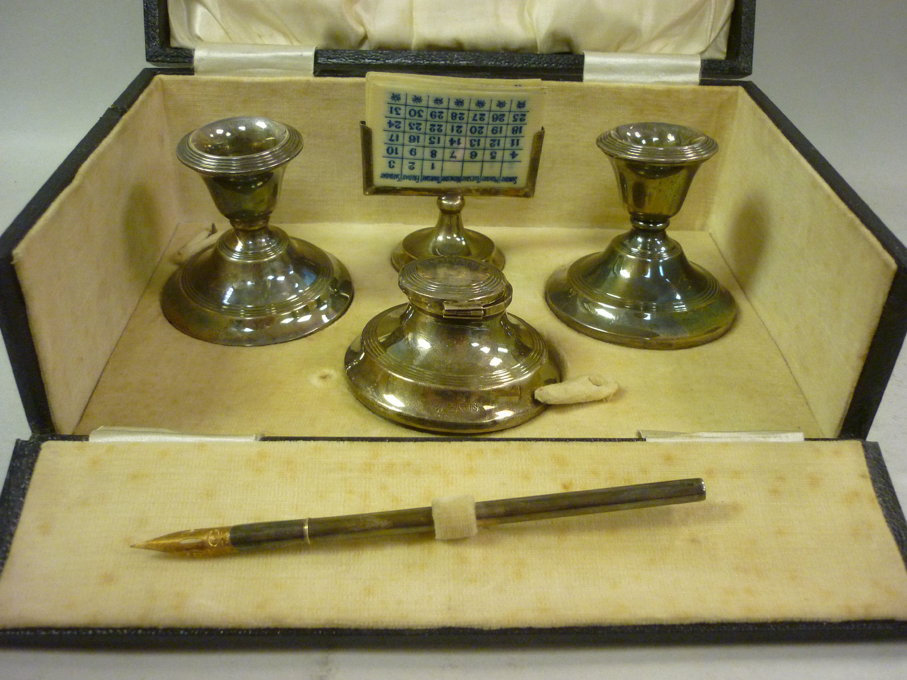 A presentation silver desk set comprising a pair of dwarf candlesticks, a capstan design inkwell,