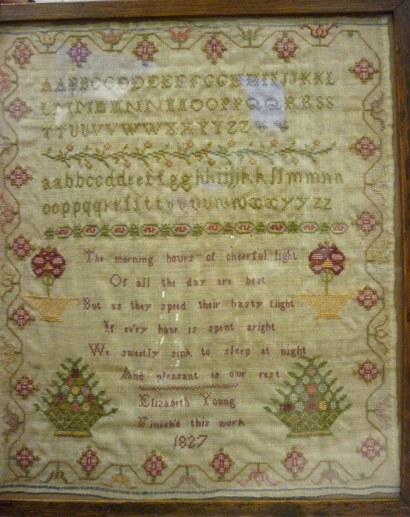 A George IV sampler, featuring the alphabet, six lines of verse and decorative border ornament,