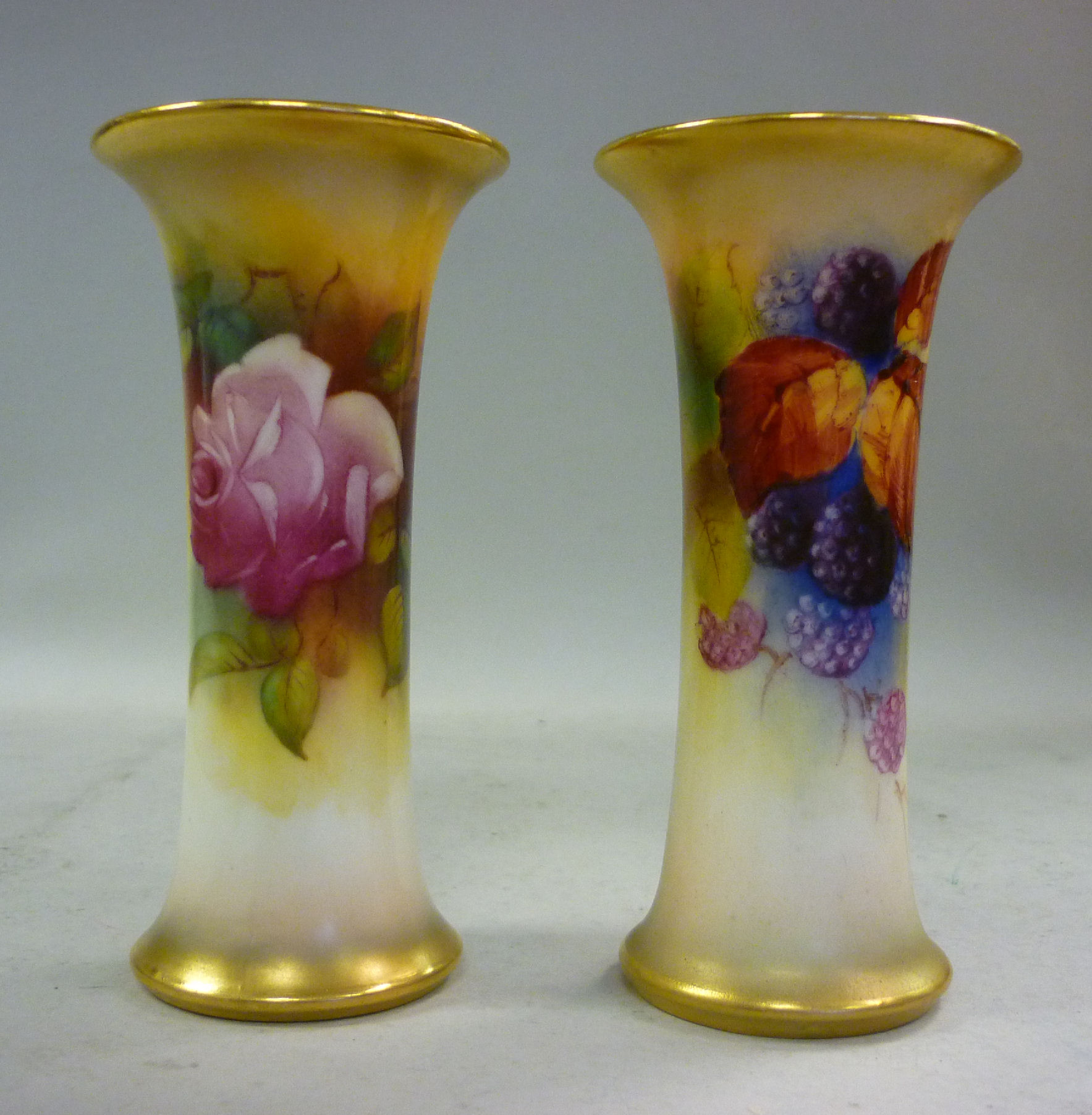 A matched pair of Royal Worcester ivory glazed china specimen vases of waisted cylindrical form,