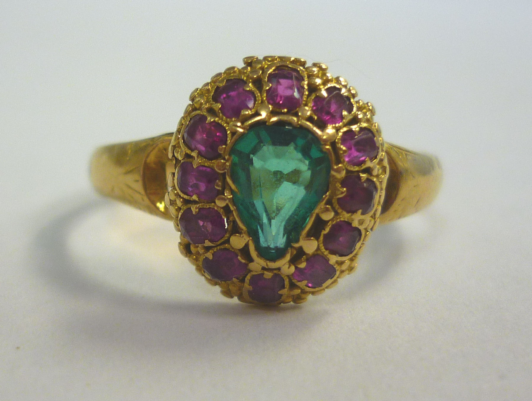 An 18ct gold ring, set with a central emerald, surrounded by rubies