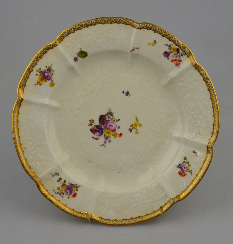 Four Meissen dinner plates moulded with flowers and painted with flower sprigs, under-glazed crossed