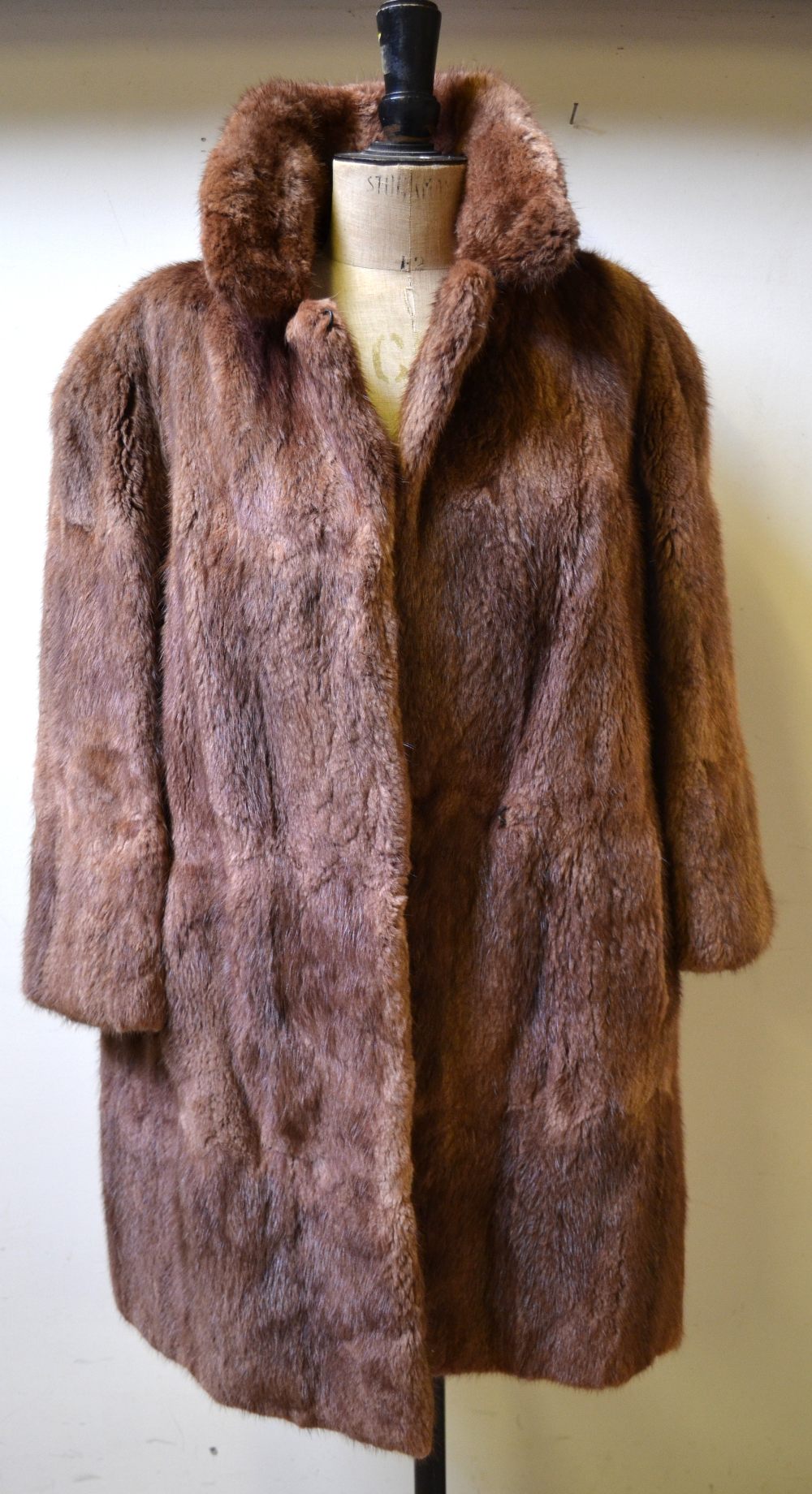 A dark brown mink fur stole with monogram, to/w a lady's musquash fur coat with brown satin