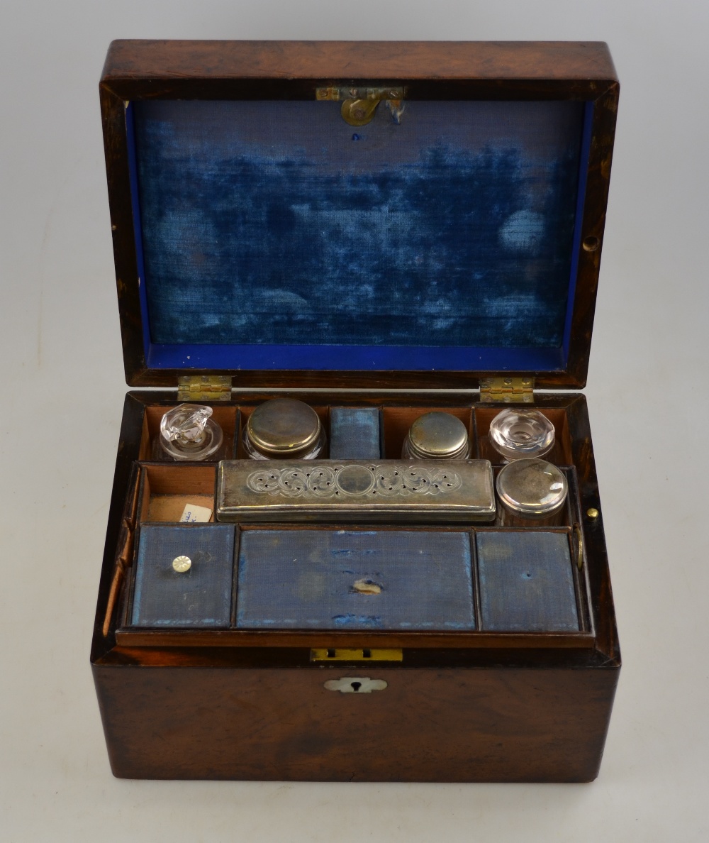 A Victorian burr walnut fitted travelling toilet box containing compartments of glass jars with ep