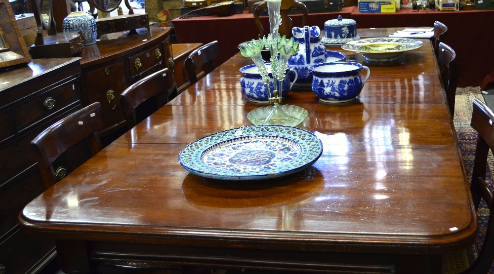 Victorian mahogany extending dining table, the wide top with rounded corners winding to accept three