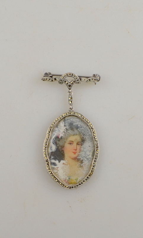 Oval pendant brooch having portrait miniature of female within marcasite set frame suspended from