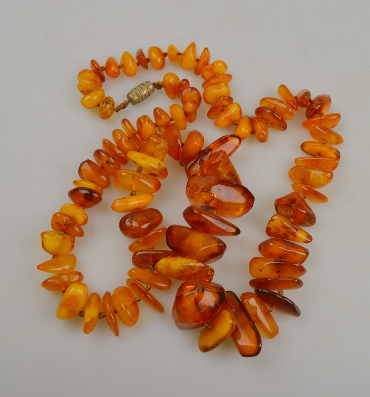 Long row of polished baroque amber beads, knotted throughout onto barrel style snap, approx 4 1/2 oz