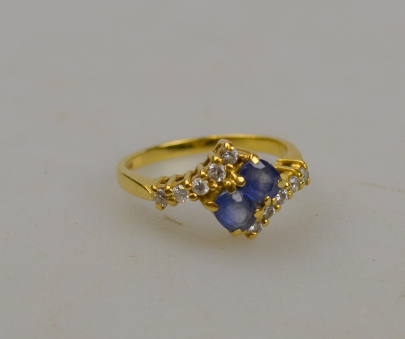 Sapphire and diamond cross over ring comprising two oval sapphire with five diamonds on either side,