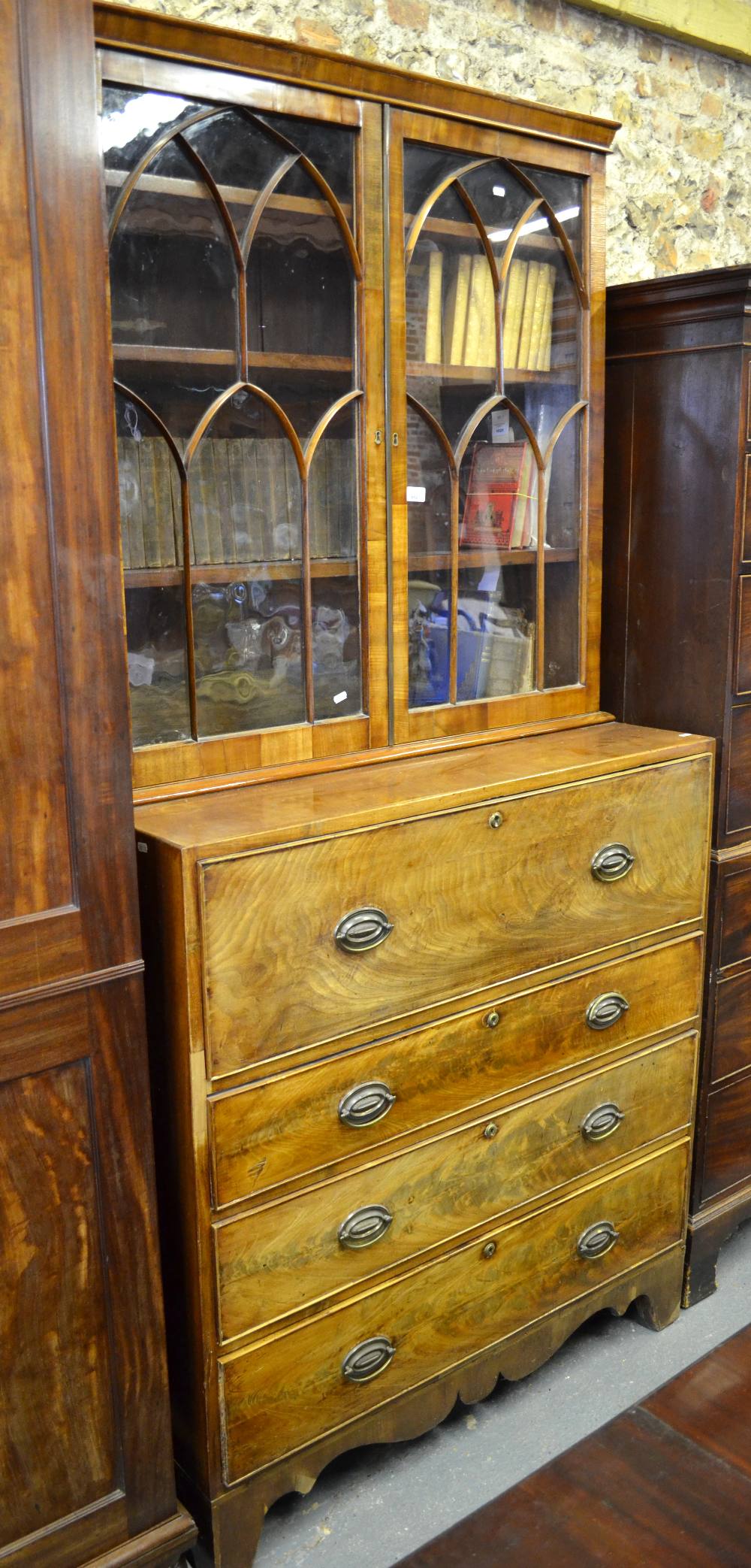 George III flame mahogany secretaire bookcase, the Gothic arched astragal glazed doors enclosing