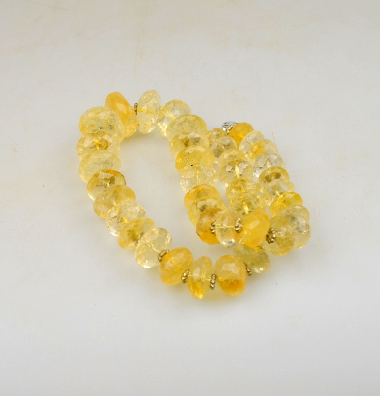 A single row of graduated facetted citrine beads, heavily included, with some rock crystal