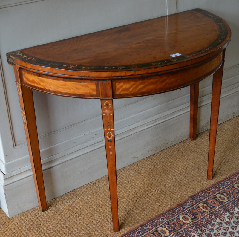 A Sheraton period cross-banded satinwood demi-lune card table, the fold over top with wide bend of