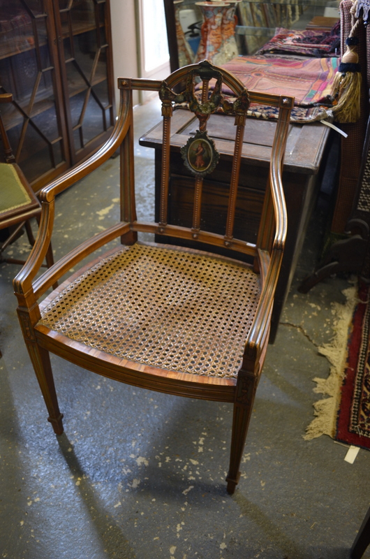 An Edwardian Sheraton Revival satinwood elbow chair, decorated in polychrome, with caned seat,