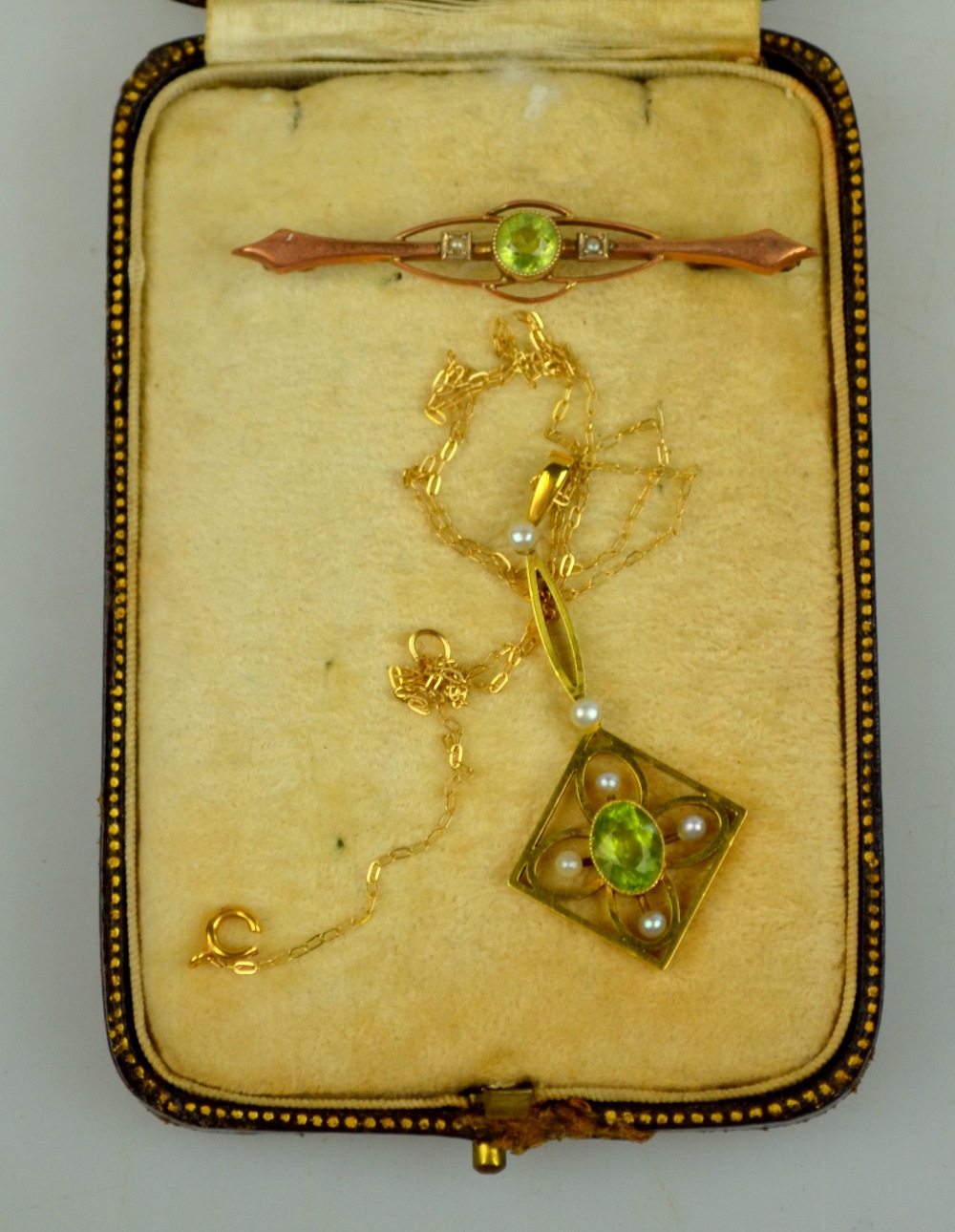 An Edwardian peridot and pearl set pendant stamped 15ct on fine gold chain to/w peridot and pearl