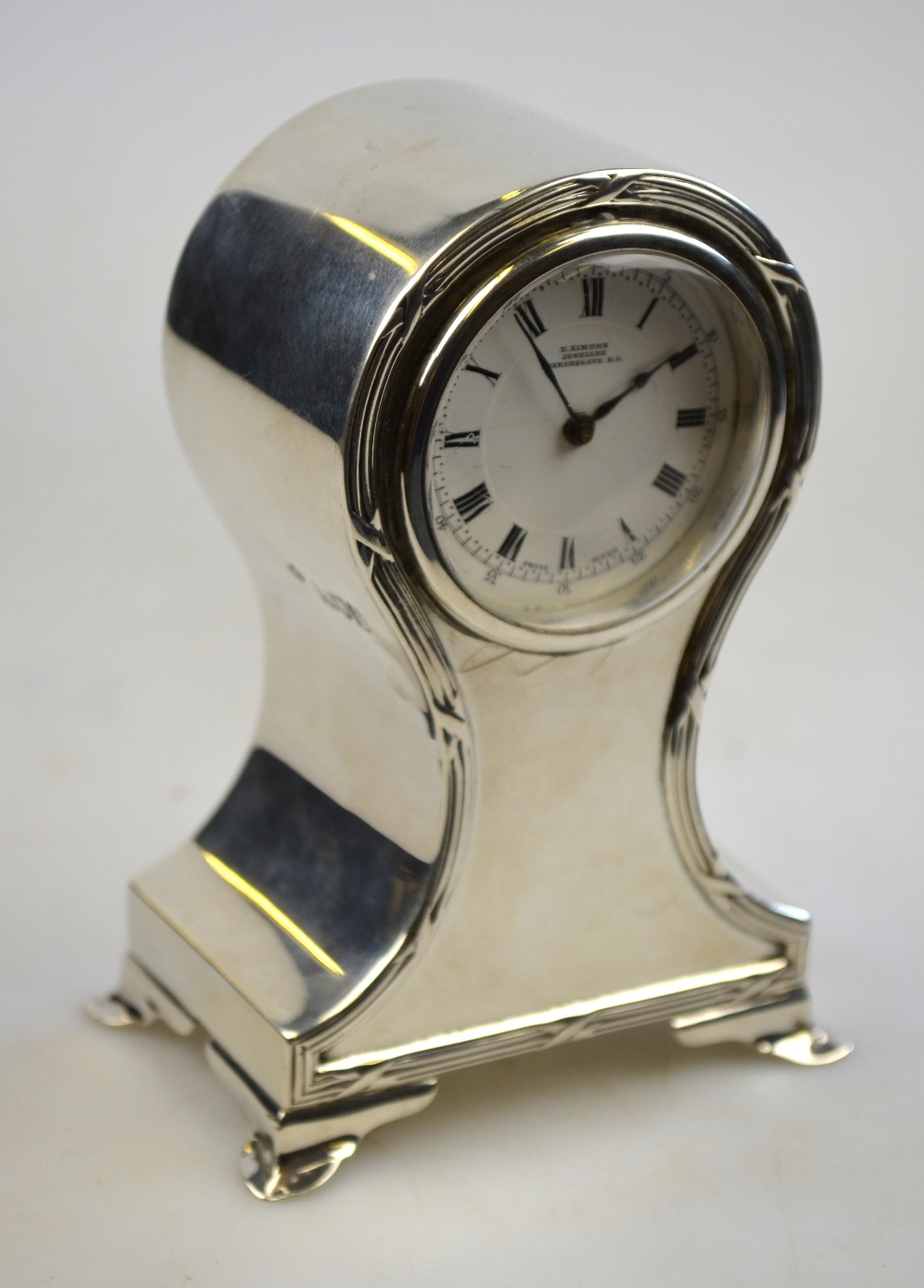 A small Edwardian silver-cased balloon clock with Swiss movement and enamel dial, inscribed for E.
