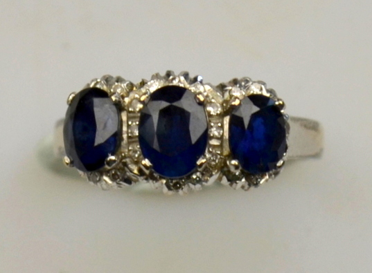 Sapphire and diamond triple cluster ring in ornate scrollwork setting, white metal set stamped 18k