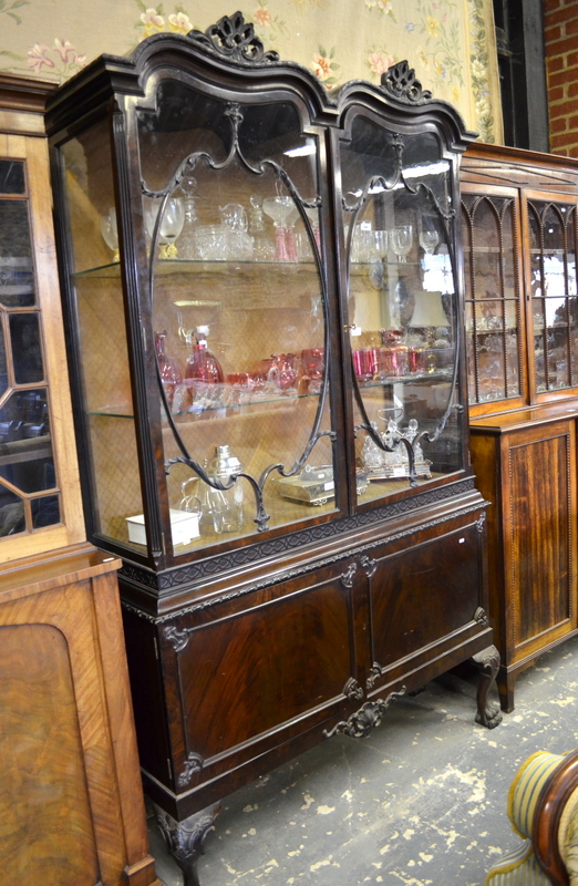 A Chippendale Revival red walnut display cabinet, the double hump top with carved edge and pierced