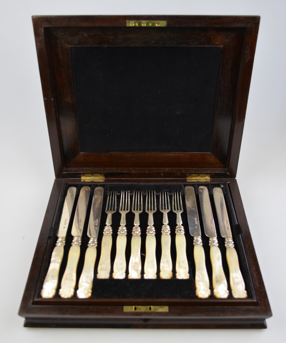 A Victorian rosewood-cased set of twelve dessert knives and forks with silver blades and carved