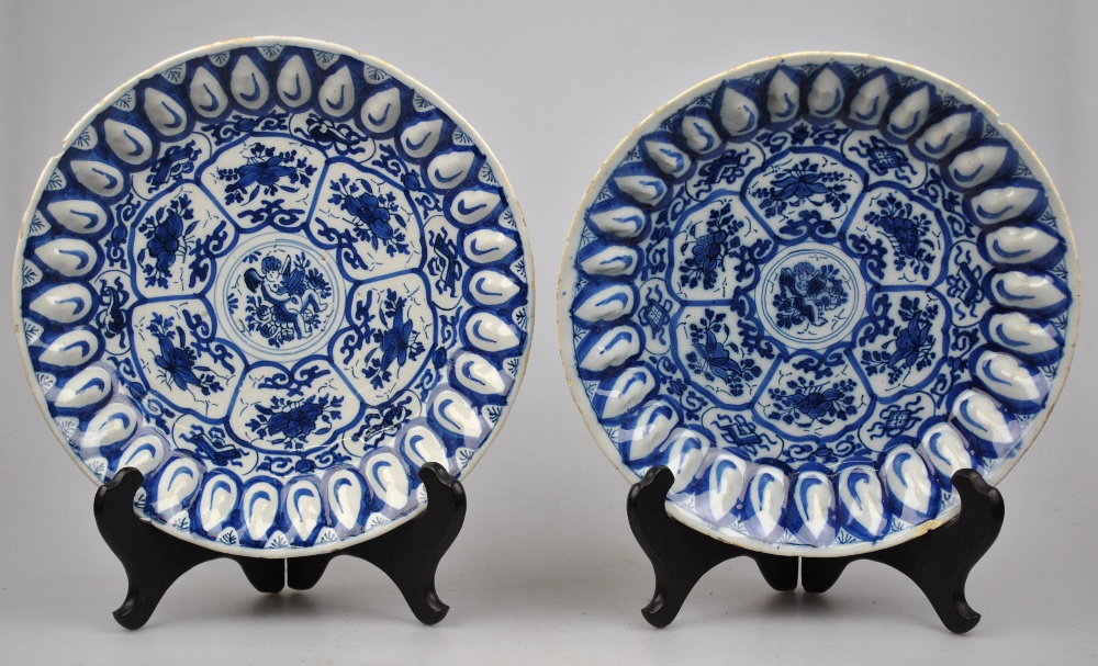 A pair of blue and white Delft bowls, the central panel decorated with a puttu surrounded by six