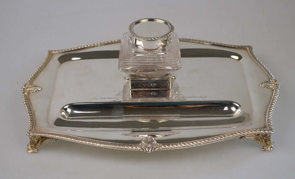 A silver inkstand fitted with a cut glass inkwell, with cast shell and gadroon rim and scroll