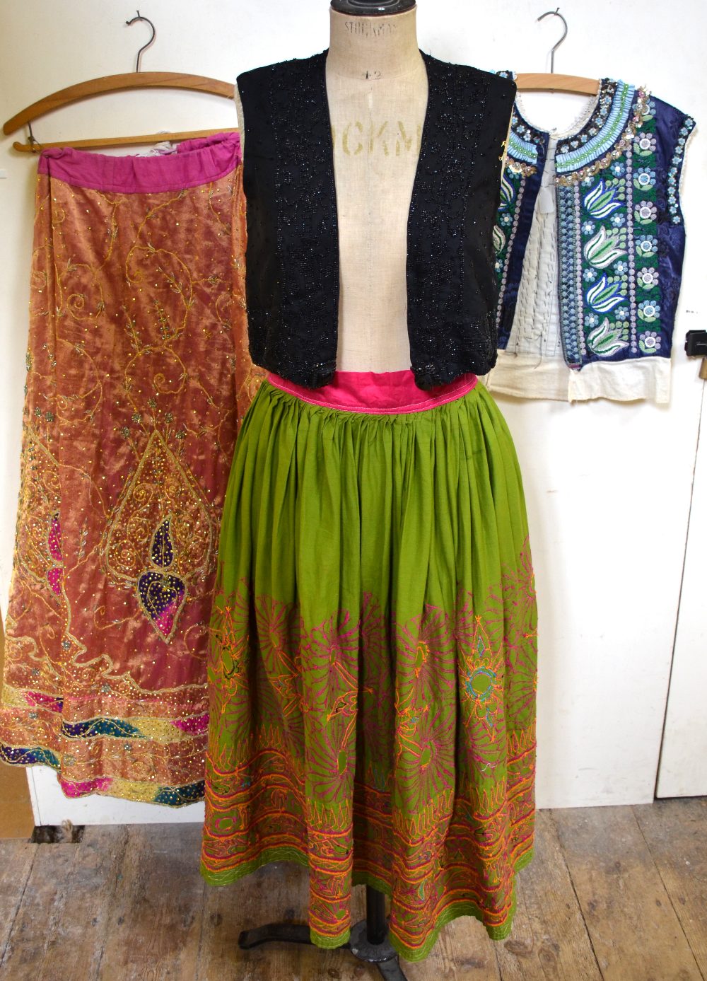 Long green cotton Indian skirt embroidered in bright pink and orange inset with mirrored circles and