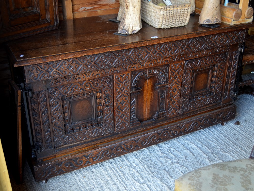 A heavy carved oak cassone, converted to a sideboard, the long frieze drawer with fancy wrought iron