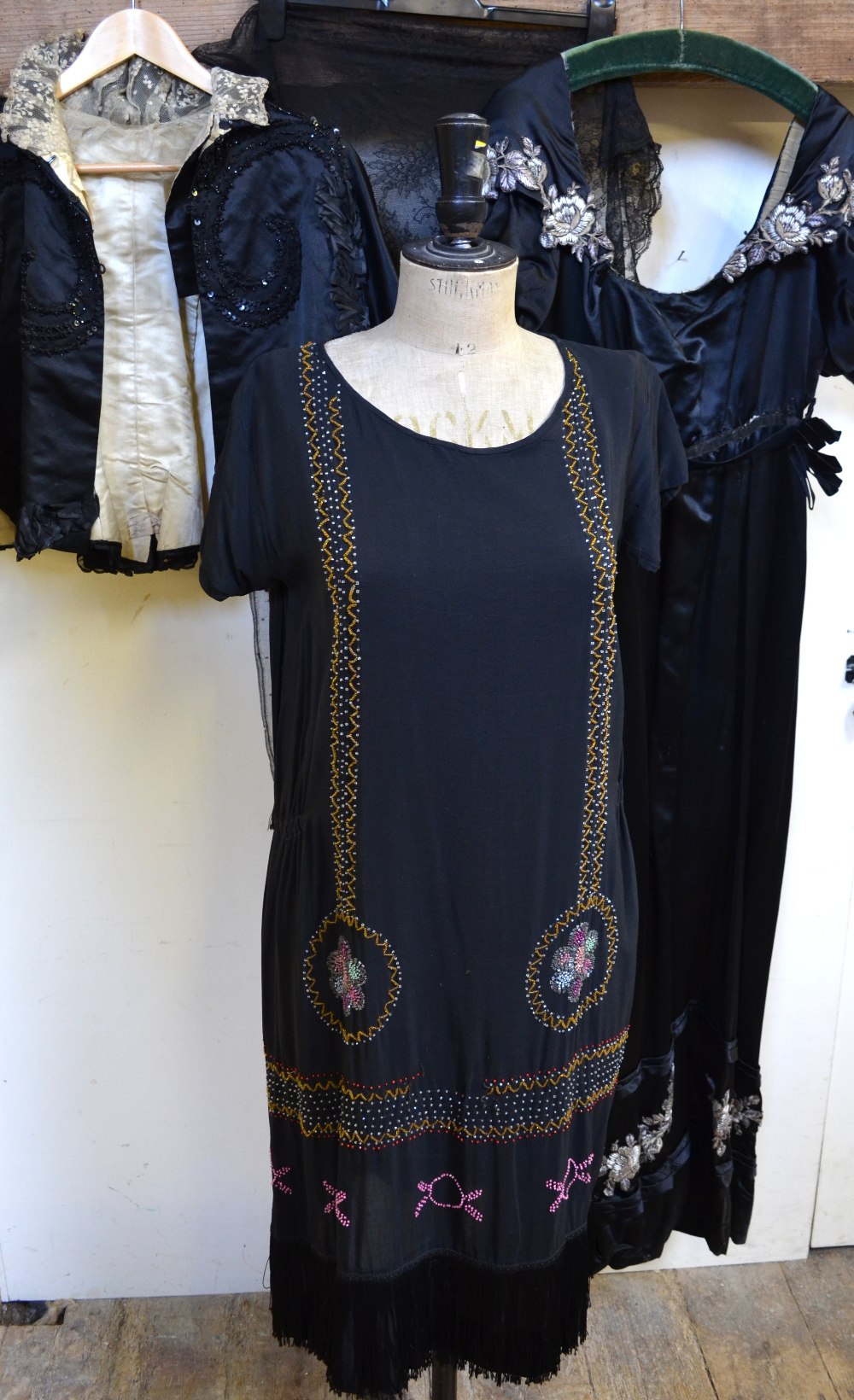 1920's black dress with multi-coloured beaded panels and roundels with fringing to hem, 50 cm across