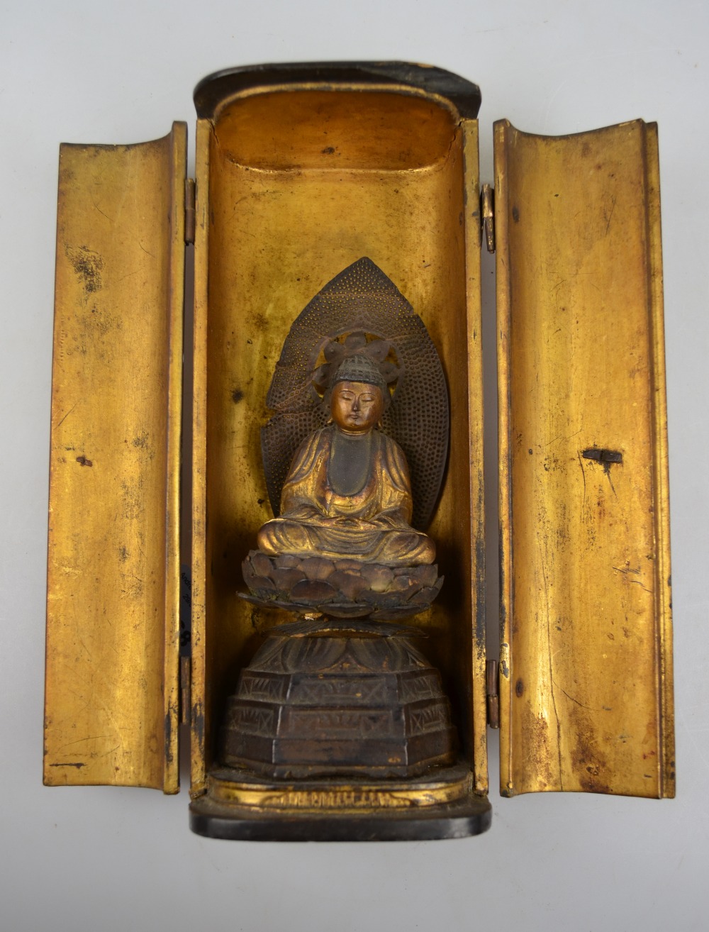 Japanese small lacquer Zushi opening to reveal a seated figure of Nyorai Buddha seated on a