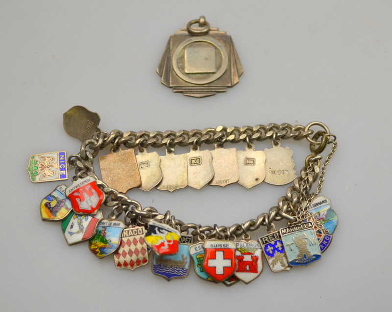 Curb bracelet with large number of enamelled souvenir shields attached, mostly stamped 800, to/w